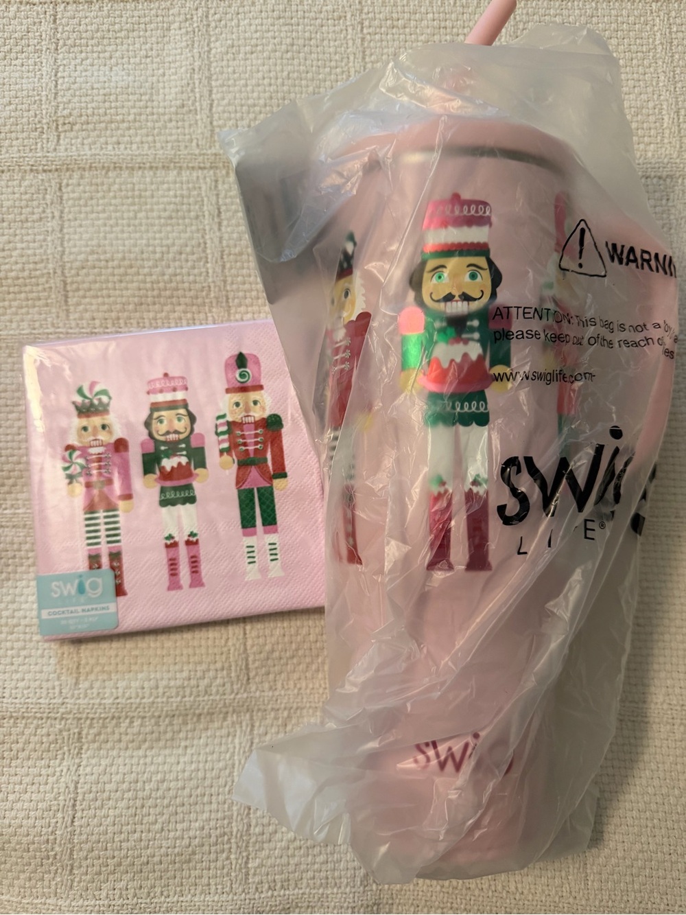 Swig Pink Nutcracker Holiday Tumbler napkins and reusable straws.